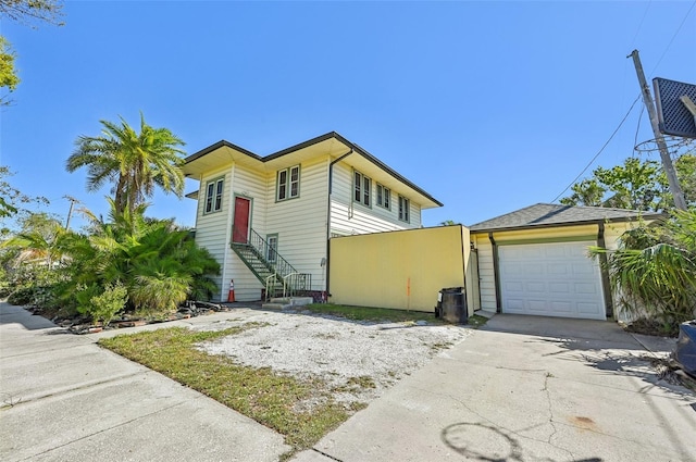 view of front of property featuring an outbuilding, concrete driveway, an attached garage, and entry steps