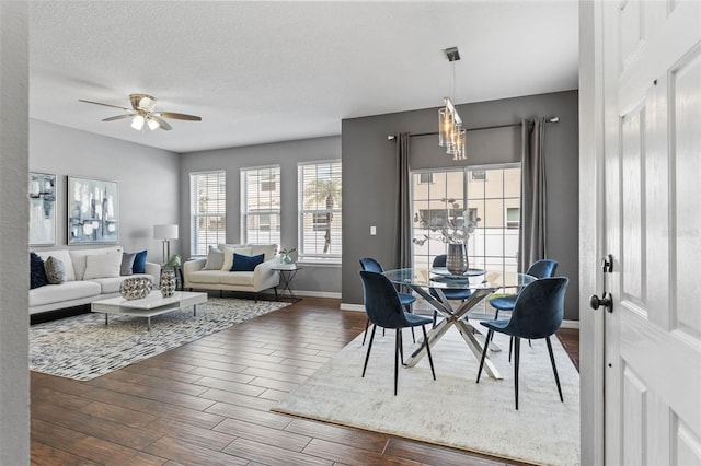 dining area with ceiling fan, baseboards, a textured ceiling, and wood finished floors