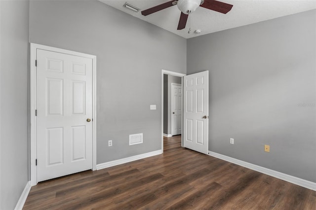 unfurnished bedroom featuring visible vents, baseboards, and dark wood-style flooring