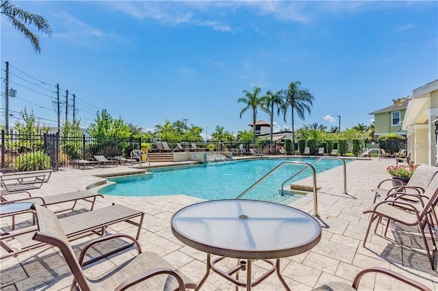 community pool featuring a patio and fence