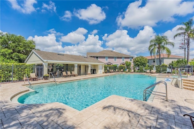 pool with fence and a patio area