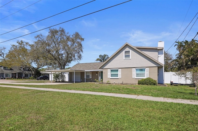 traditional home featuring an attached carport, a front yard, and driveway