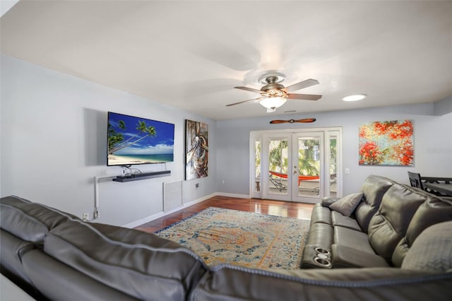 living area featuring wood finished floors, visible vents, baseboards, ceiling fan, and french doors