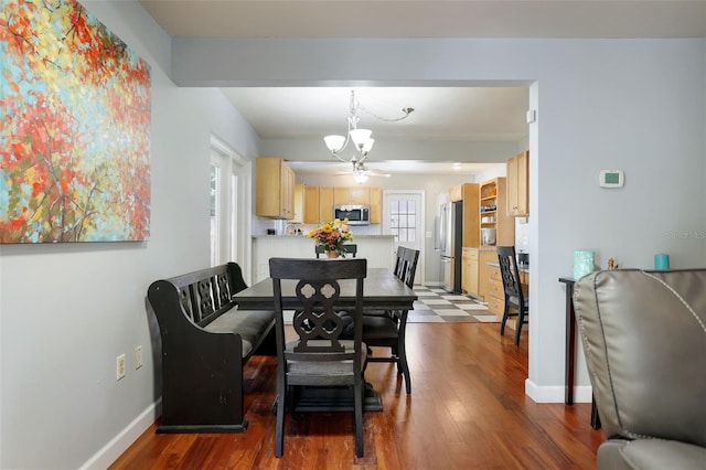 dining room featuring ceiling fan, baseboards, and dark wood-style flooring