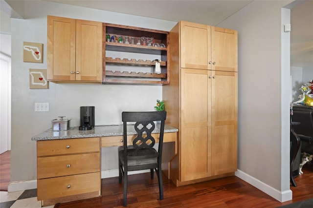 office space with dark wood finished floors, built in desk, and baseboards