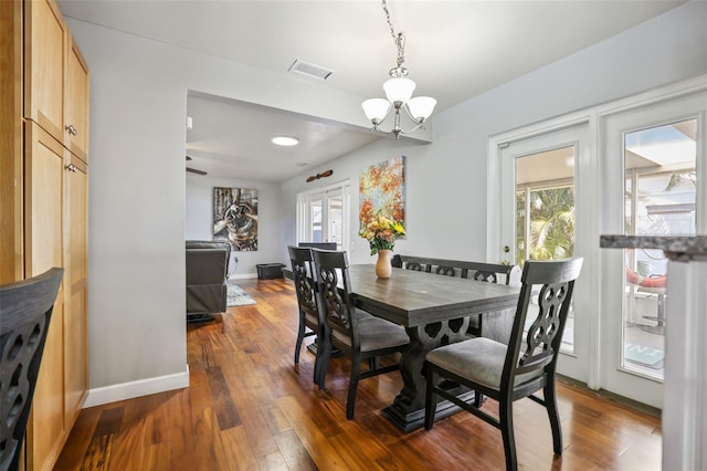 dining space with baseboards, visible vents, dark wood-style flooring, french doors, and a chandelier