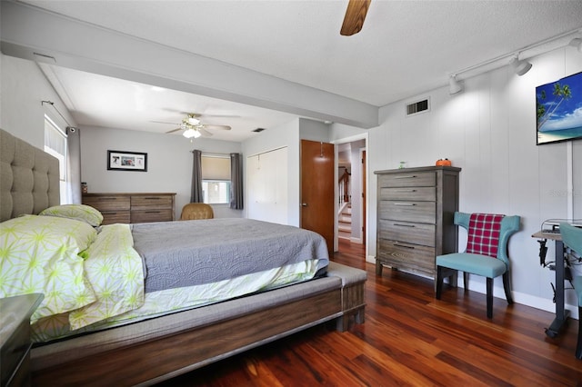 bedroom featuring visible vents, multiple windows, wood finished floors, and track lighting