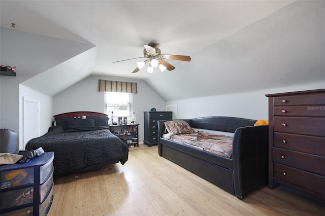 bedroom with light wood finished floors, a ceiling fan, and vaulted ceiling