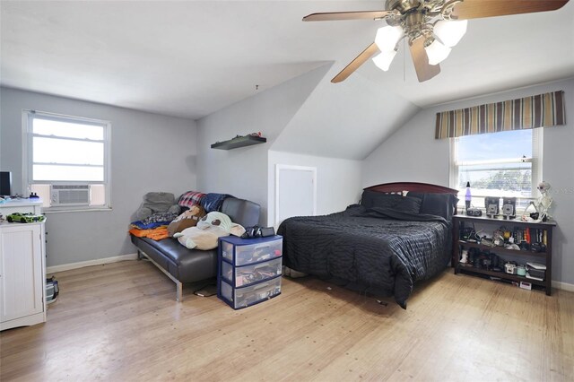 bedroom featuring vaulted ceiling, cooling unit, wood finished floors, and baseboards