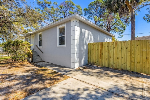 view of property exterior with fence and stucco siding