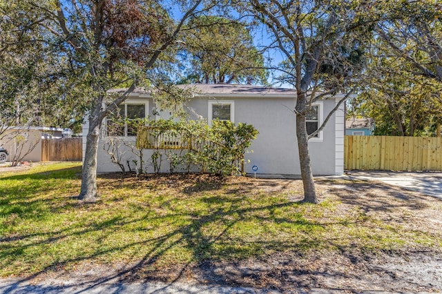 exterior space with a yard, fence, and stucco siding