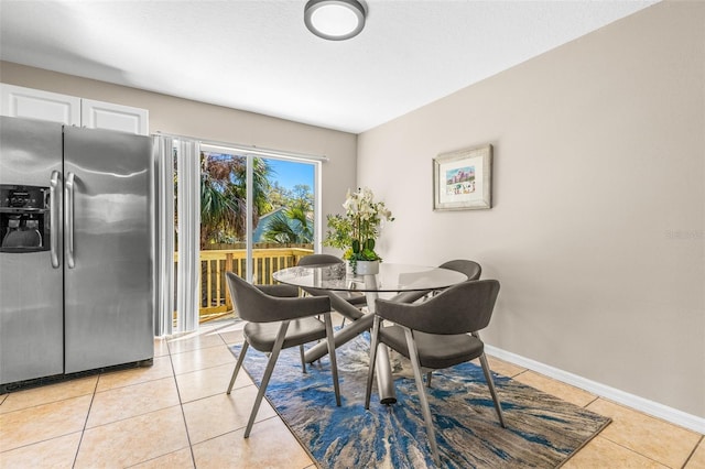 dining area with baseboards and light tile patterned flooring