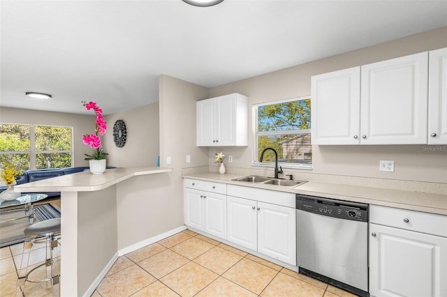 kitchen featuring a sink, dishwasher, a peninsula, and light countertops