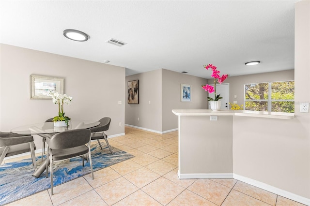 dining area featuring light tile patterned floors, visible vents, and baseboards