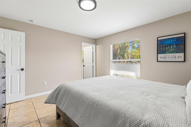 bedroom with light tile patterned floors and baseboards