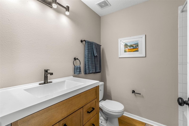 full bathroom featuring visible vents, toilet, wood finished floors, baseboards, and vanity