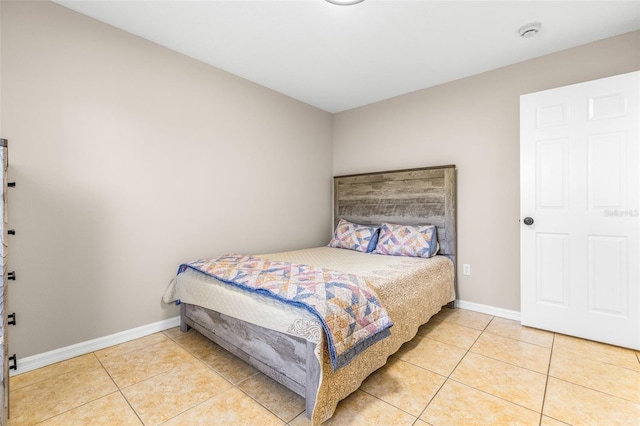 bedroom with baseboards and tile patterned flooring