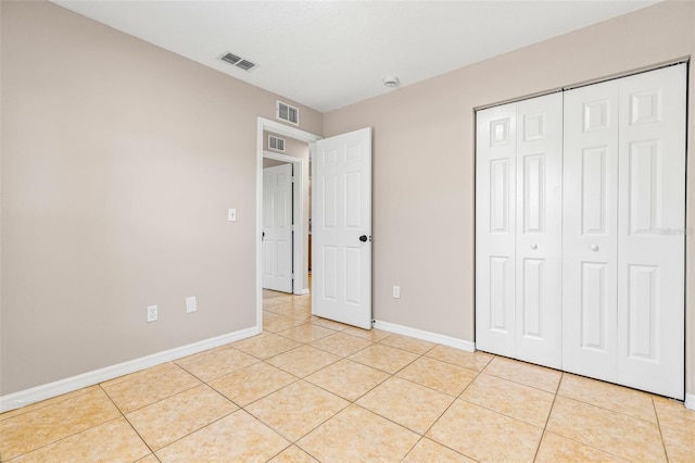 unfurnished bedroom featuring light tile patterned floors, baseboards, and visible vents