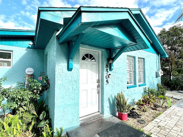 view of exterior entry featuring stucco siding