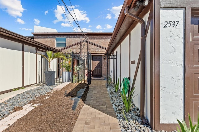 view of property exterior with brick siding and fence