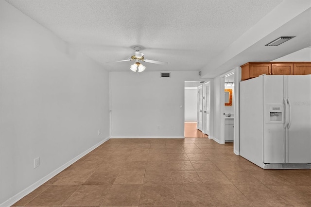 interior space with ceiling fan, visible vents, white fridge with ice dispenser, and brown cabinets