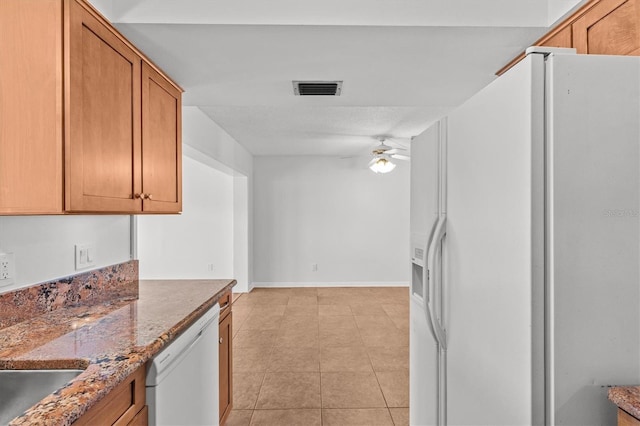 kitchen featuring white appliances, light tile patterned floors, brown cabinetry, a ceiling fan, and visible vents