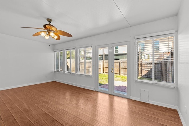 unfurnished sunroom featuring ceiling fan