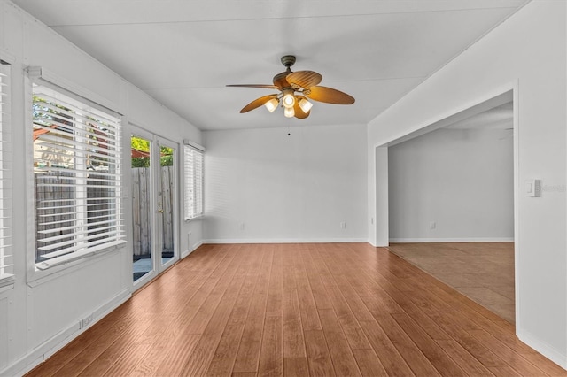 unfurnished room featuring wood finished floors, baseboards, and ceiling fan