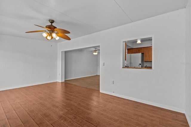 spare room with ceiling fan, baseboards, and wood finished floors