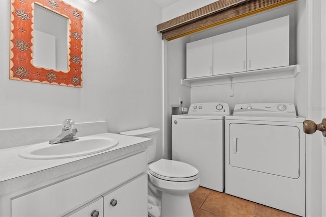 half bath with tile patterned flooring, toilet, vanity, and separate washer and dryer