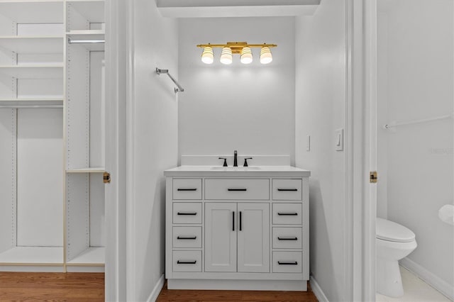 bathroom featuring vanity, toilet, and baseboards