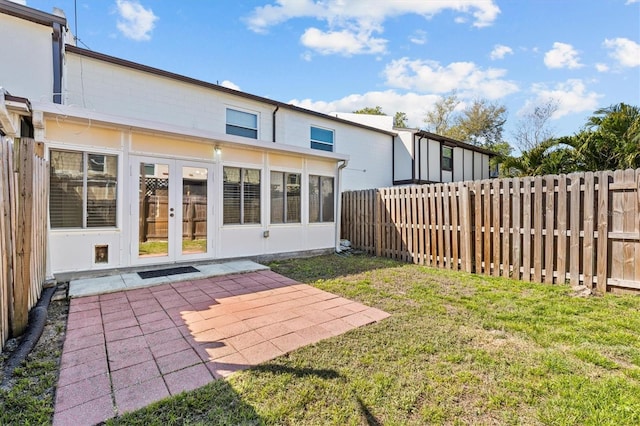 back of house with a patio, a yard, french doors, and a fenced backyard