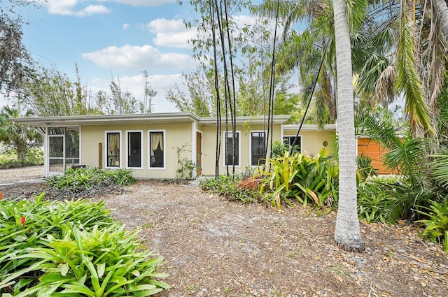 view of front of property featuring stucco siding and a sunroom