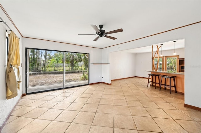 unfurnished room with crown molding, light tile patterned flooring, a wealth of natural light, and ceiling fan