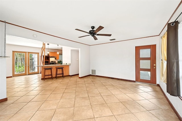 unfurnished living room with light tile patterned flooring, visible vents, and ornamental molding