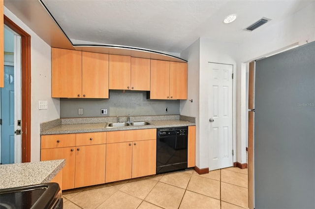 kitchen featuring visible vents, dishwasher, light tile patterned floors, freestanding refrigerator, and a sink