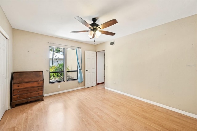 unfurnished bedroom featuring light wood-type flooring, visible vents, baseboards, and a ceiling fan