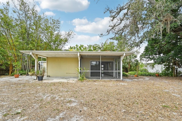 rear view of house featuring a sunroom