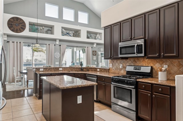 kitchen featuring dark brown cabinets, decorative backsplash, appliances with stainless steel finishes, and light tile patterned floors