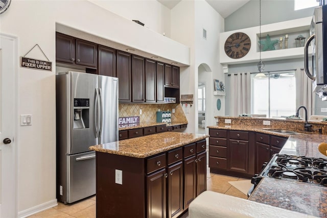 kitchen featuring light tile patterned floors, dark brown cabinetry, stainless steel refrigerator with ice dispenser, and a sink