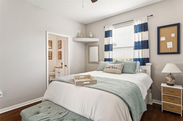 bedroom featuring wood finished floors, baseboards, ensuite bathroom, and ceiling fan