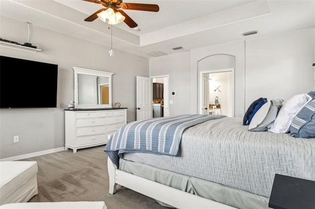 bedroom with visible vents, light carpet, a raised ceiling, baseboards, and ceiling fan