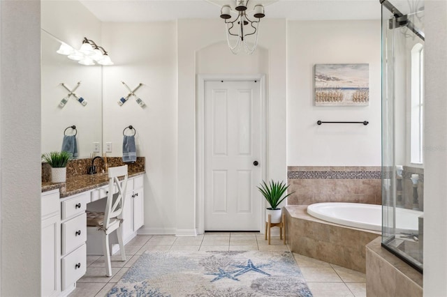 bathroom featuring tile patterned flooring, a garden tub, vanity, and an inviting chandelier