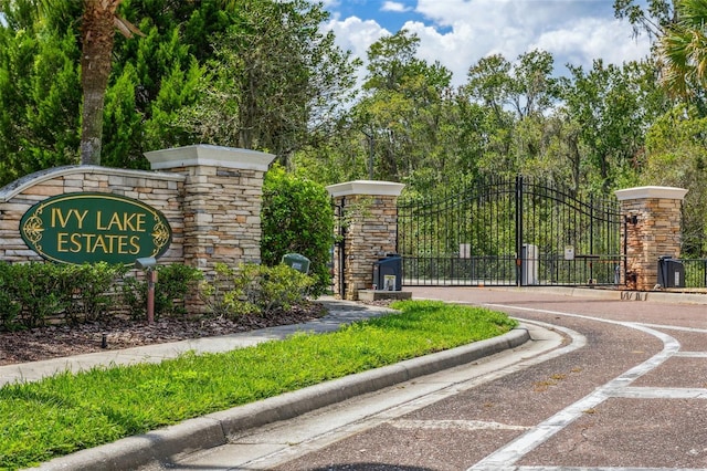 community / neighborhood sign featuring a gate