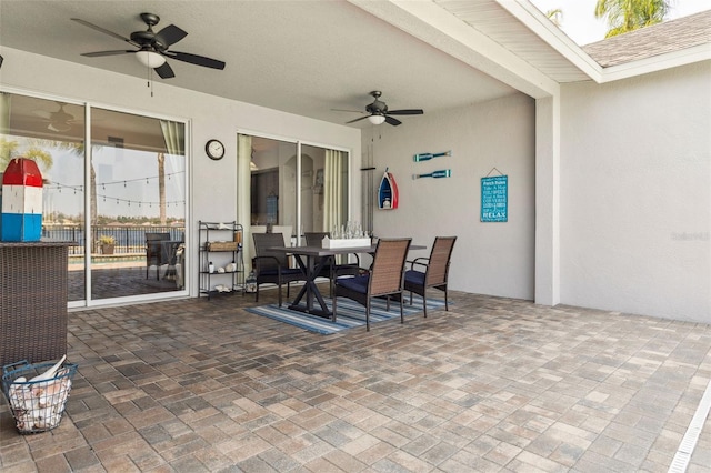 view of patio with outdoor dining area and a ceiling fan