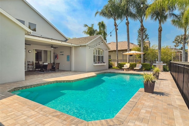 view of swimming pool featuring a fenced in pool, a patio, ceiling fan, and fence