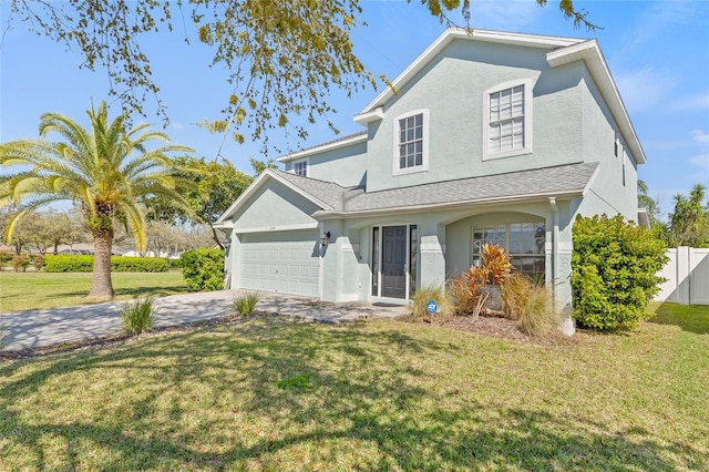 view of front facade with fence, a front yard, stucco siding, decorative driveway, and an attached garage