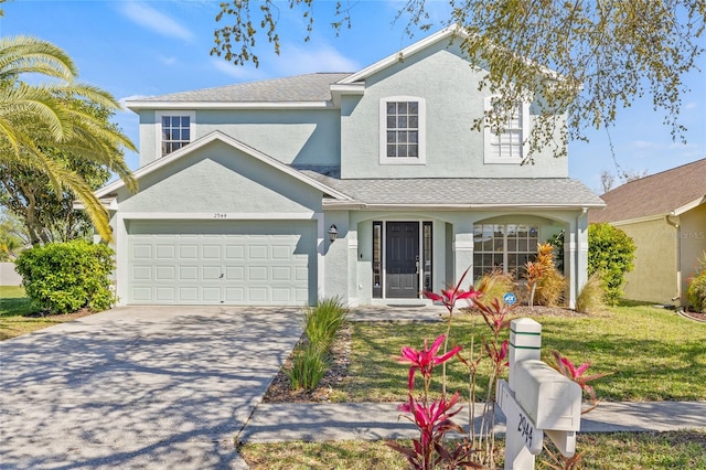 traditional home with a front yard, a garage, driveway, and stucco siding