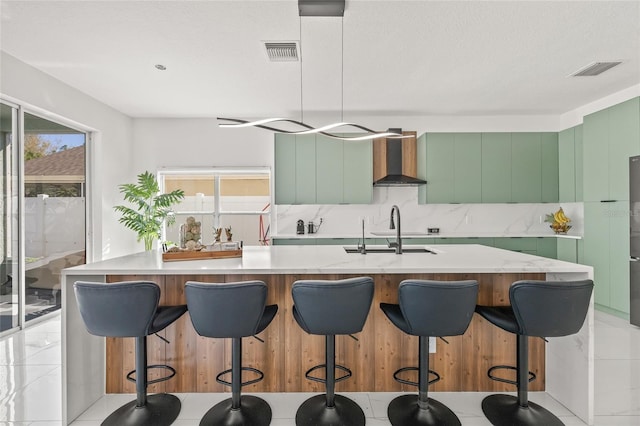 kitchen featuring tasteful backsplash, visible vents, modern cabinets, and wall chimney range hood