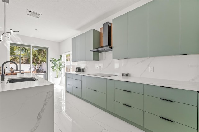 kitchen featuring a sink, decorative backsplash, wall chimney exhaust hood, black electric cooktop, and marble finish floor